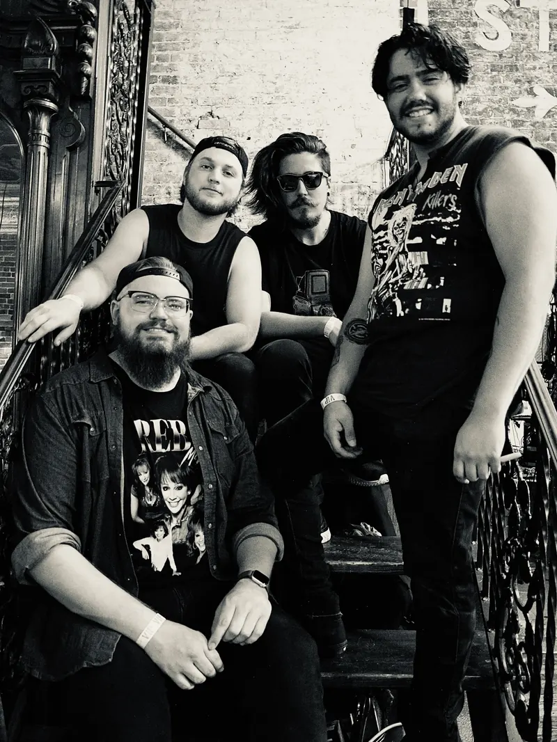 Black and white promo portrait of Radio City Renegades on an iron staircase
