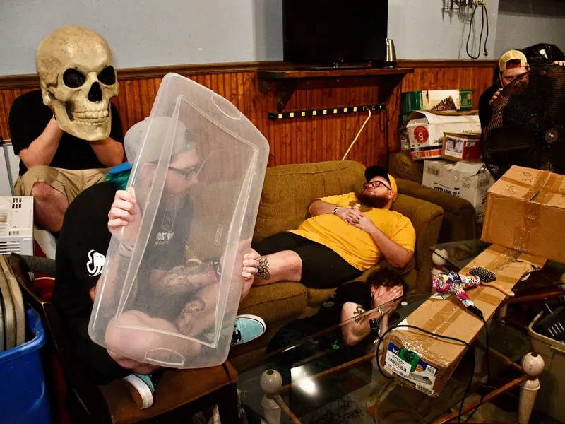 Backstage gag with a skull and a plastic tub over a band member’s head