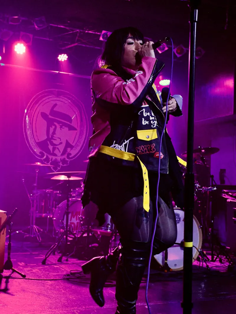 Laken of Eye Candy mid-kick on a magenta-lit stage