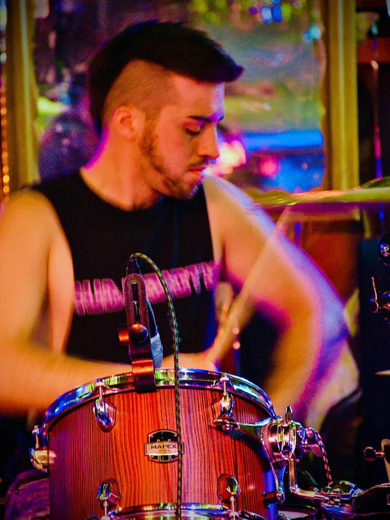 Drummer with a mohawk mid-beat