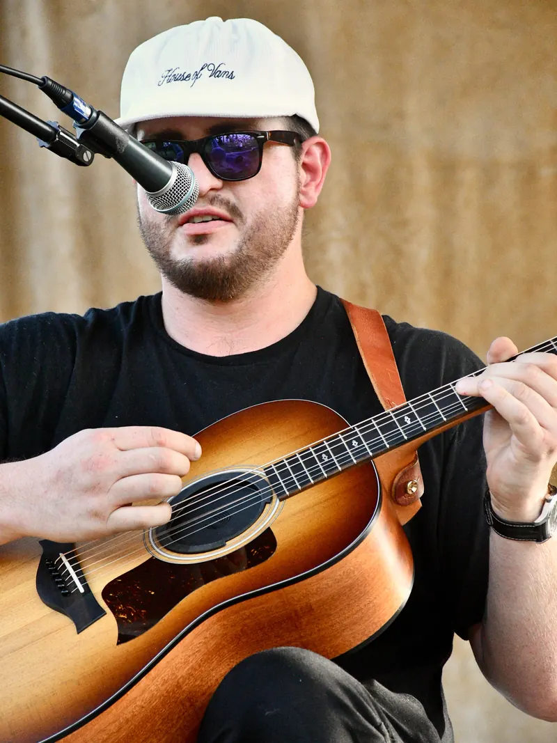 Acoustic guitarist in a white cap and sunglasses